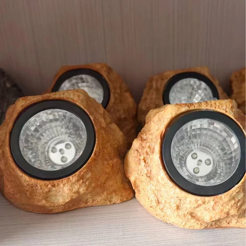 Solarbetriebener LED-Gartenstrahler in Felsoptik mit integriertem Solarpanel und wetterfestem Gehäuse aus strukturiertem Harz Skanto