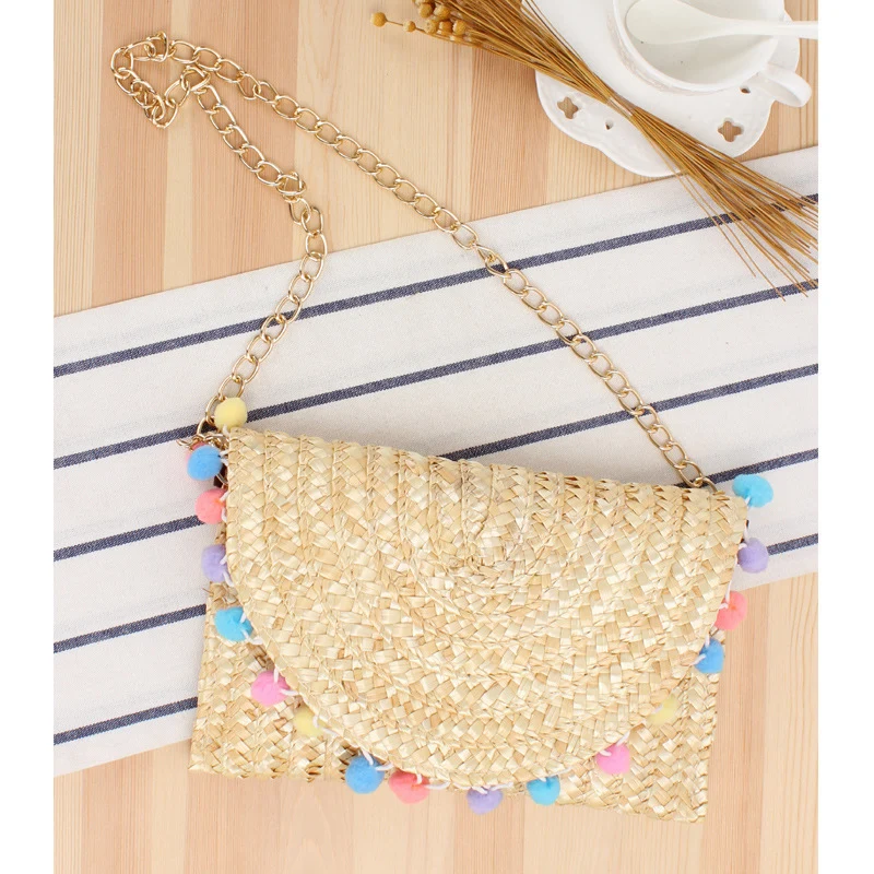 Handgewebte Raffia-Clutch mit dekorativen Pompons Skanto